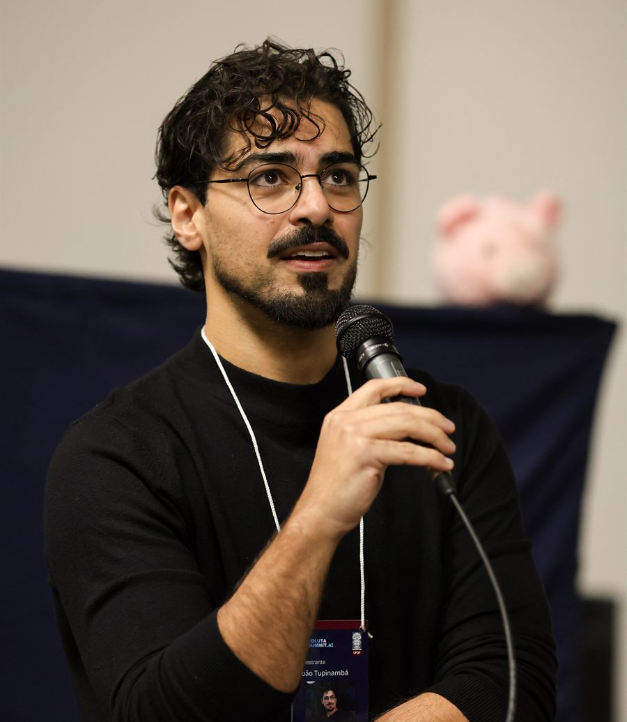 João Tupinambá com o microfone, ouvindo uma conversa